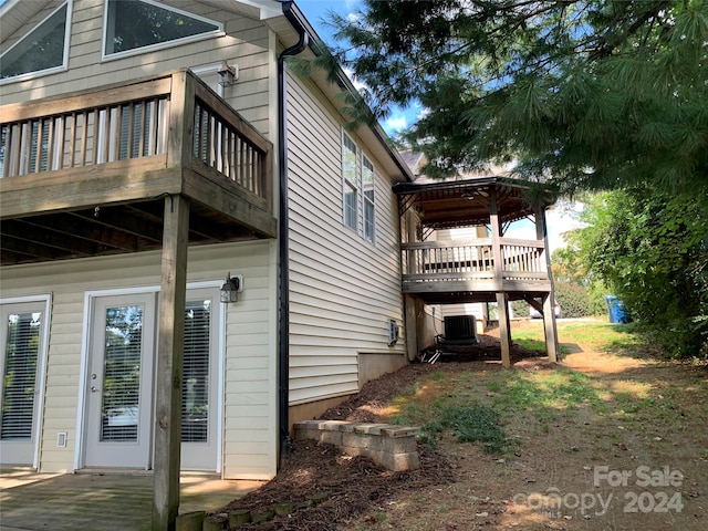 view of property exterior with central AC unit and a deck