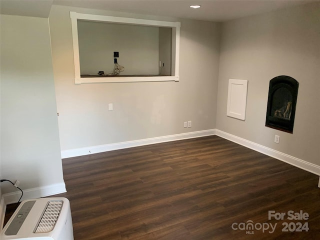 unfurnished room with dark wood-type flooring