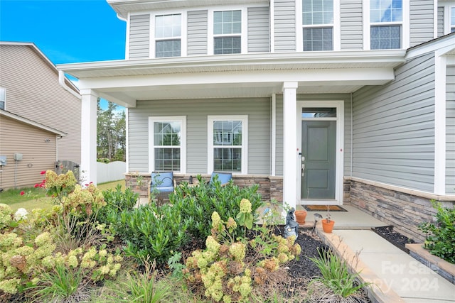 entrance to property with covered porch and central air condition unit