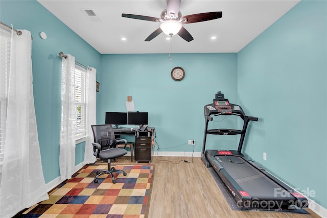 exercise room featuring light hardwood / wood-style flooring and ceiling fan