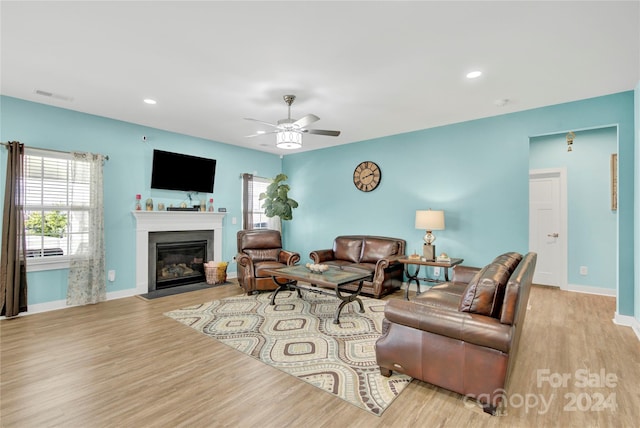 living room featuring ceiling fan and light hardwood / wood-style flooring