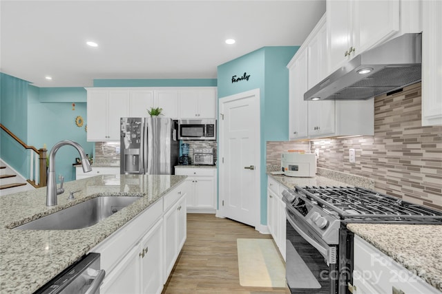 kitchen with stainless steel appliances, white cabinets, light wood-type flooring, and ventilation hood