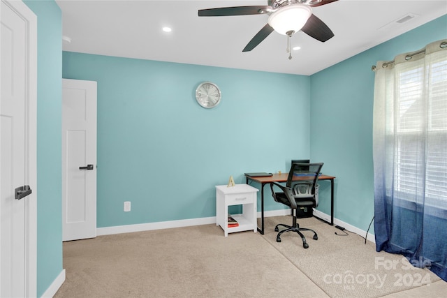 carpeted office space with ceiling fan