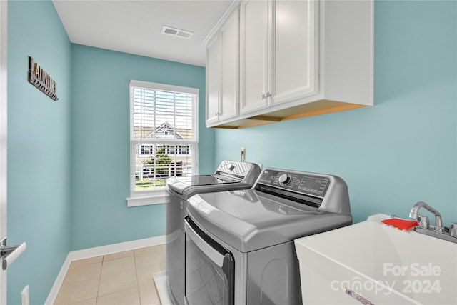 washroom featuring cabinets, independent washer and dryer, light tile patterned floors, and sink