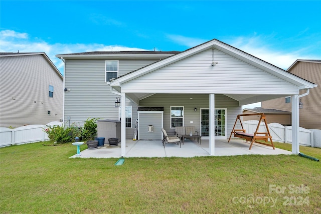 rear view of property featuring a lawn and a patio area