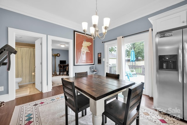 dining area with crown molding, a chandelier, and dark hardwood / wood-style flooring