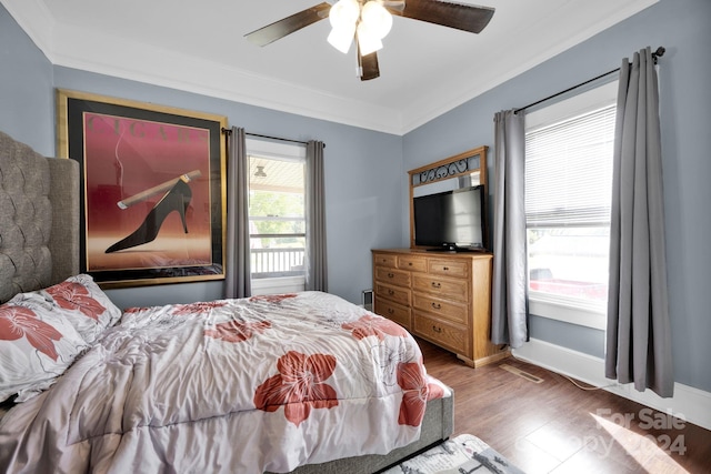 bedroom featuring ornamental molding, ceiling fan, and dark wood-type flooring