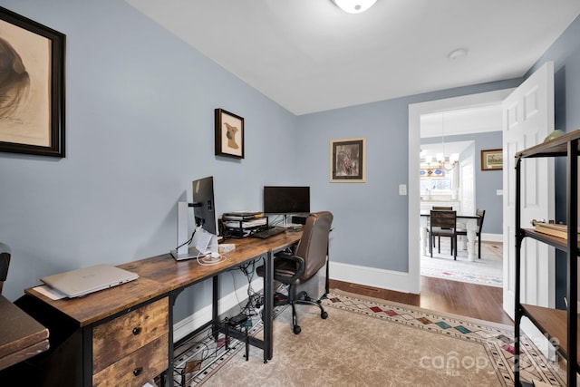 office space with light wood-type flooring and an inviting chandelier