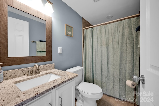 bathroom with a shower with curtain, wood-type flooring, vanity, and toilet