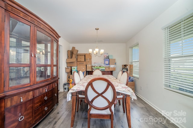 dining room with dark wood-type flooring, baseboards, and a notable chandelier