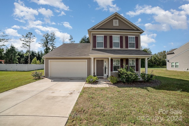 traditional-style house with a garage, fence, concrete driveway, and a front lawn