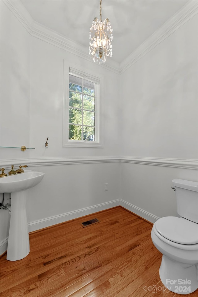 bathroom featuring ornamental molding, sink, wood-type flooring, a notable chandelier, and toilet