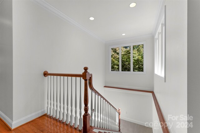 stairs with crown molding and hardwood / wood-style floors