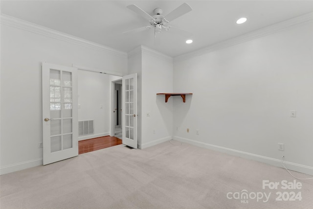 unfurnished bedroom featuring french doors, light colored carpet, ornamental molding, and ceiling fan