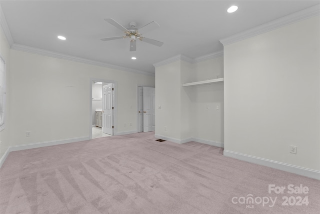 carpeted spare room featuring crown molding and ceiling fan