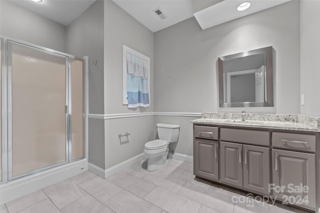 bathroom with vanity, tile patterned flooring, toilet, and a shower with door