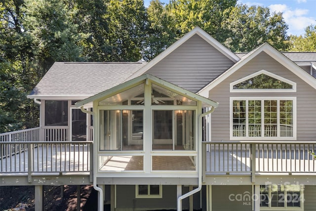 rear view of property with a sunroom and a wooden deck