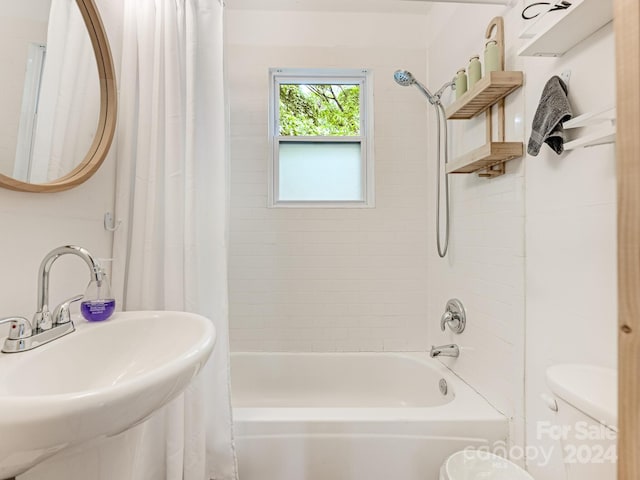 full bathroom featuring shower / tub combo with curtain, sink, and toilet