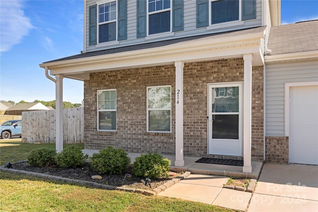 entrance to property featuring a garage and a porch