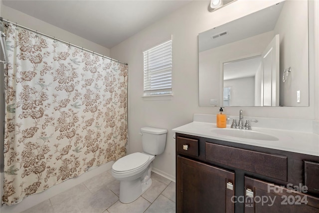 bathroom featuring tile patterned flooring, a shower with curtain, vanity, and toilet