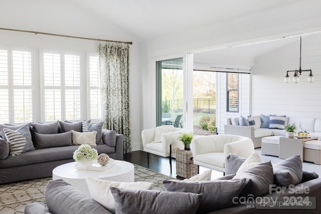 living room featuring wood-type flooring, vaulted ceiling, wood walls, and a wealth of natural light