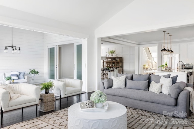 living room featuring light hardwood / wood-style floors, lofted ceiling, and a chandelier