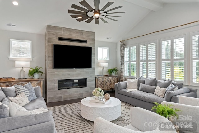 living room with ceiling fan, a tiled fireplace, hardwood / wood-style floors, and a wealth of natural light