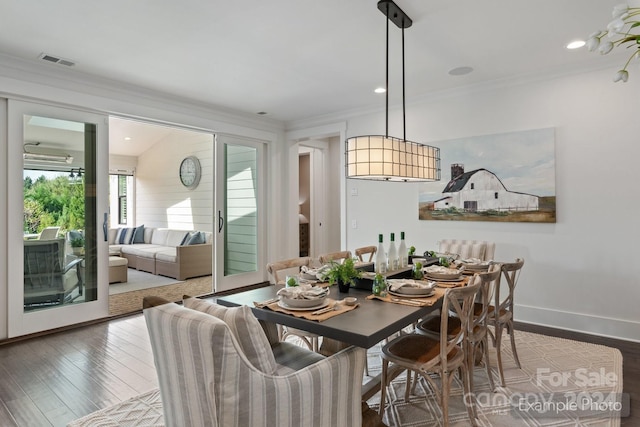 dining space featuring wood-type flooring and ornamental molding