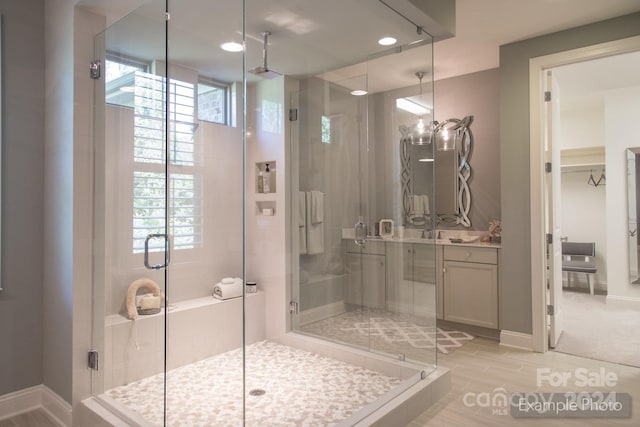 bathroom with a healthy amount of sunlight, vanity, hardwood / wood-style floors, and a shower with shower door