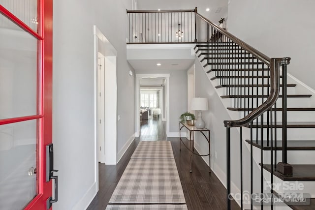 entrance foyer with dark wood-type flooring and a high ceiling