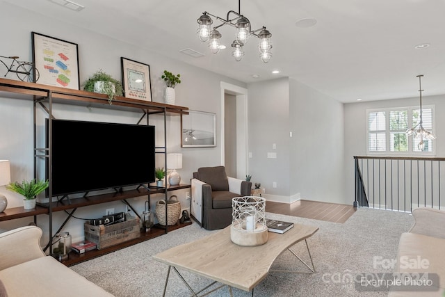 living room featuring an inviting chandelier and wood-type flooring