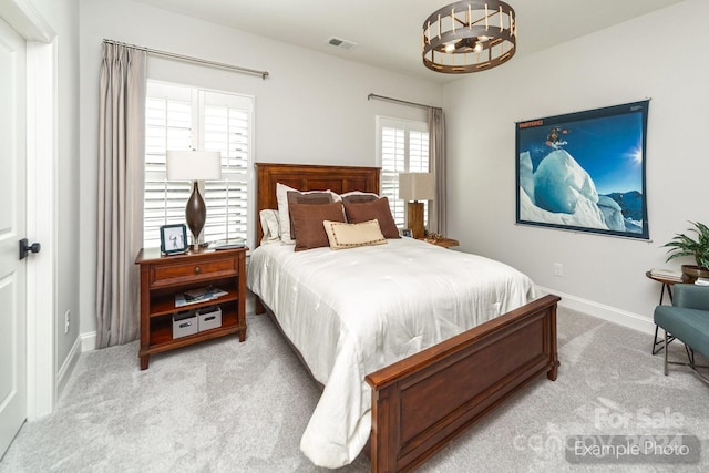 carpeted bedroom with a chandelier