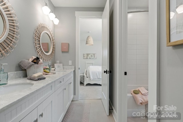 bathroom featuring a tile shower, tile patterned floors, and vanity