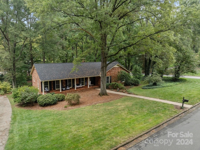 ranch-style house with a front lawn and covered porch