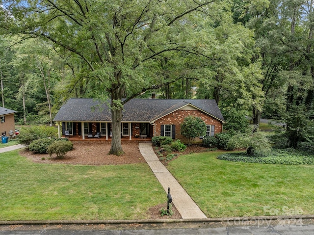 ranch-style home featuring a front lawn and covered porch