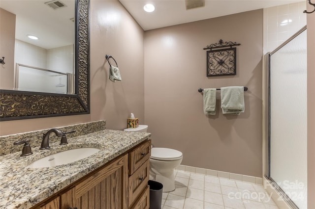 bathroom featuring tile patterned flooring, a shower with door, vanity, and toilet