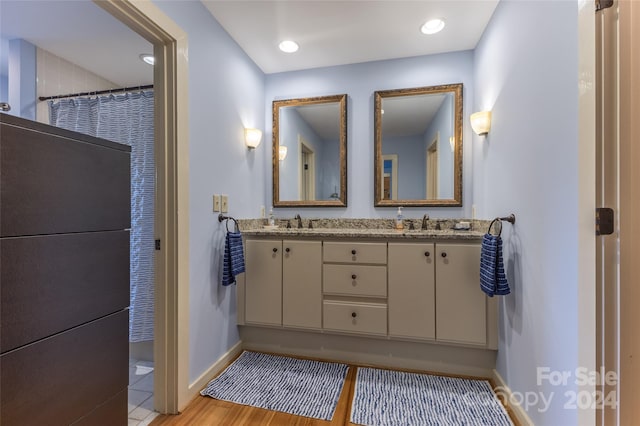 bathroom with a shower with curtain, hardwood / wood-style flooring, and vanity