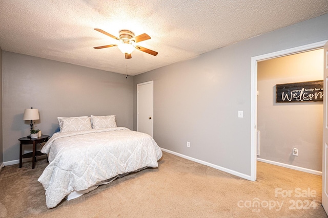 carpeted bedroom with ceiling fan and a textured ceiling