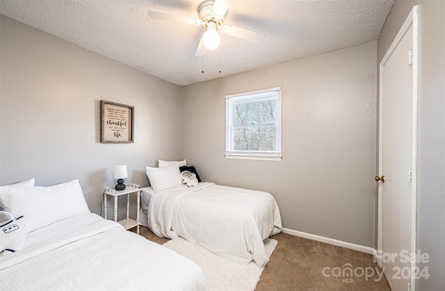 bedroom featuring ceiling fan, carpet floors, and a textured ceiling