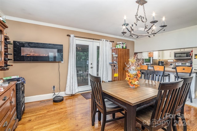 dining room with an inviting chandelier, light wood-type flooring, ornamental molding, and a healthy amount of sunlight