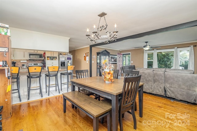 dining space with ceiling fan with notable chandelier, light hardwood / wood-style flooring, and crown molding