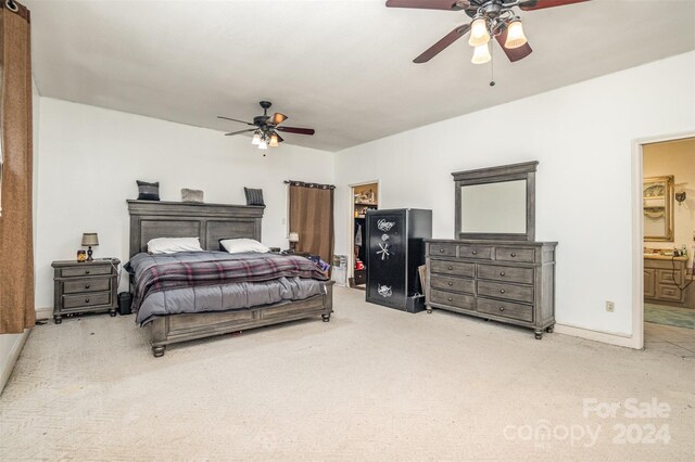 carpeted bedroom featuring ensuite bath and ceiling fan