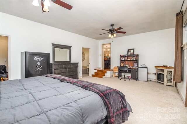 carpeted bedroom with ensuite bath and ceiling fan