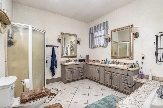 bathroom featuring tile patterned floors, walk in shower, vanity, and toilet