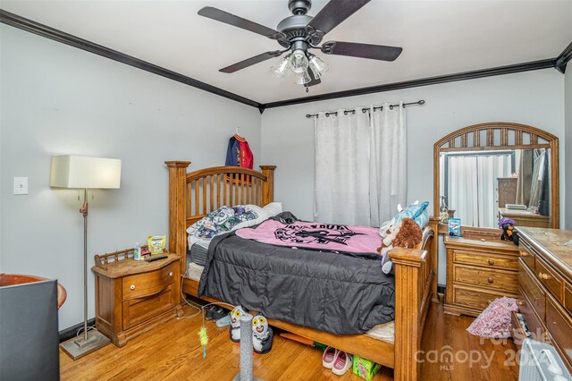 bedroom featuring light hardwood / wood-style flooring, ceiling fan, and ornamental molding