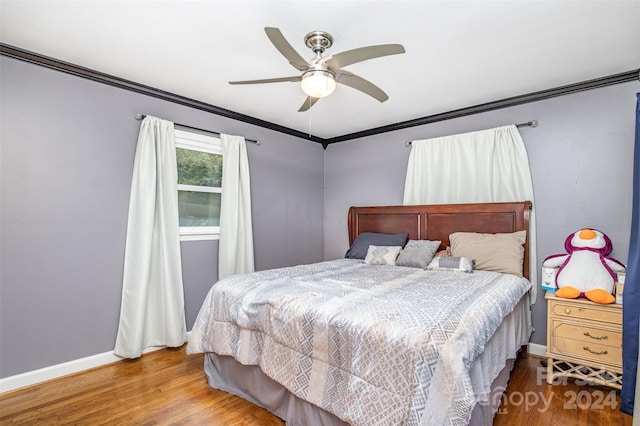 bedroom featuring ceiling fan, crown molding, and hardwood / wood-style floors