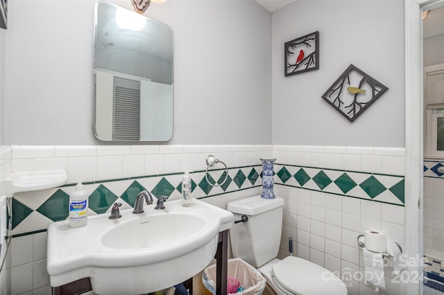 bathroom featuring tile walls and toilet