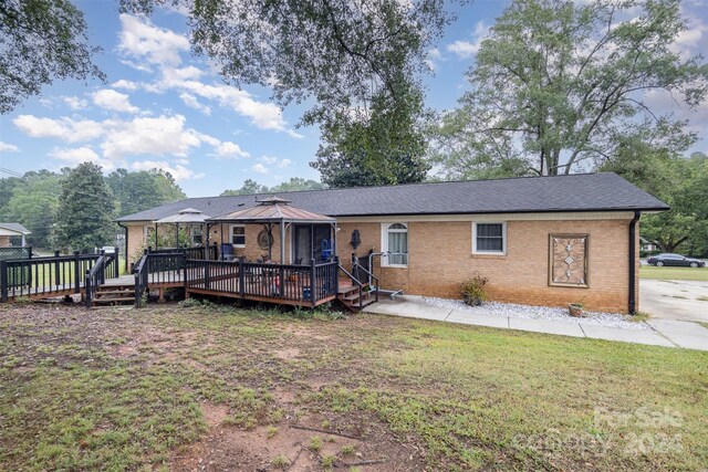 exterior space featuring a wooden deck and a lawn