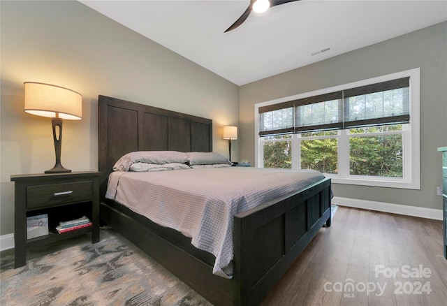 bedroom with ceiling fan, hardwood / wood-style flooring, and vaulted ceiling