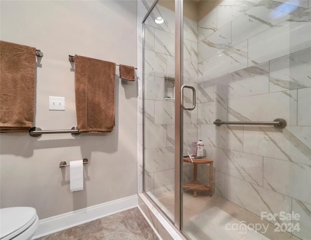 bathroom featuring toilet and an enclosed shower